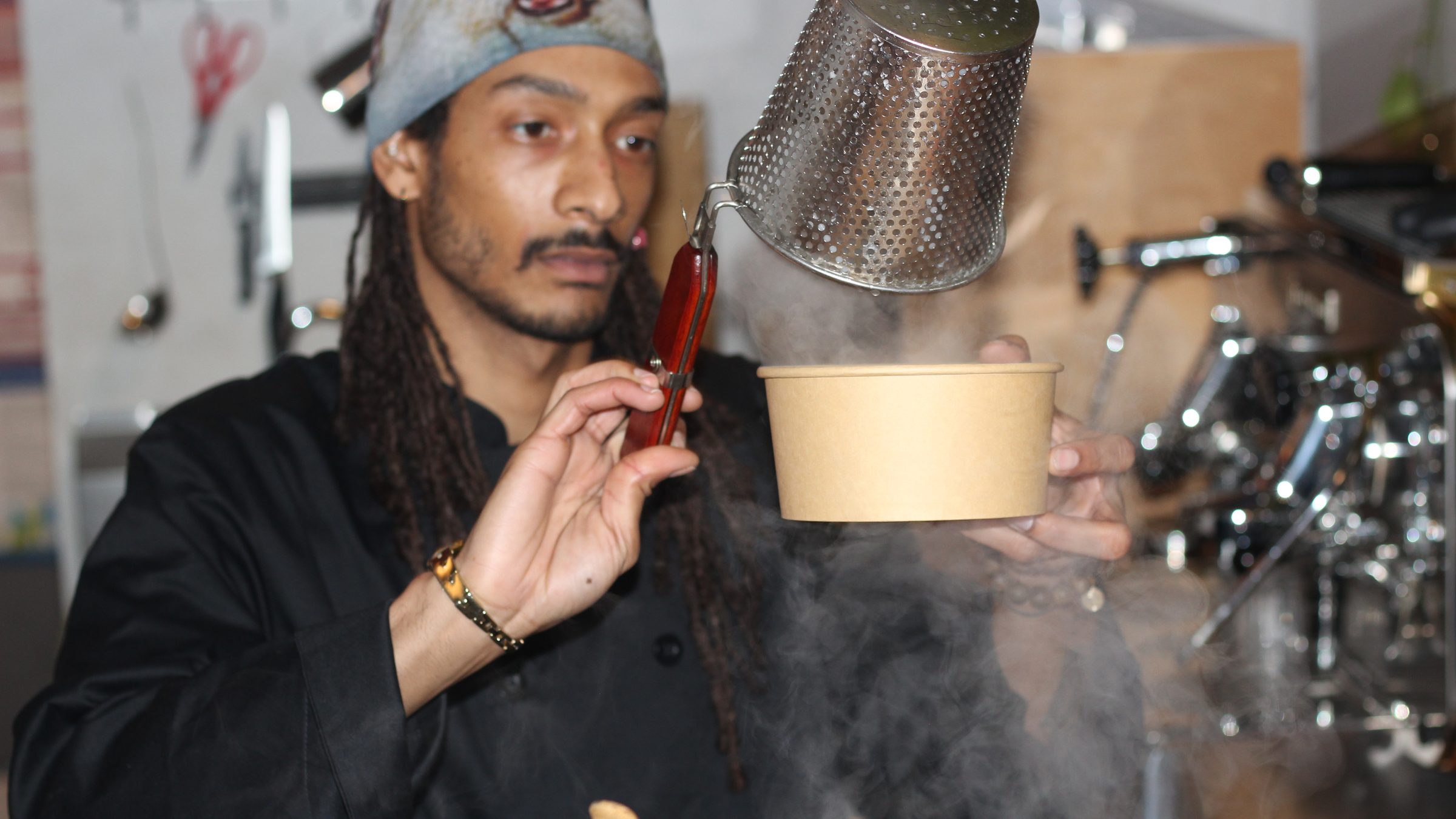 The chef lifting a steaming strainer over a bowl at the Pho Pop-Up