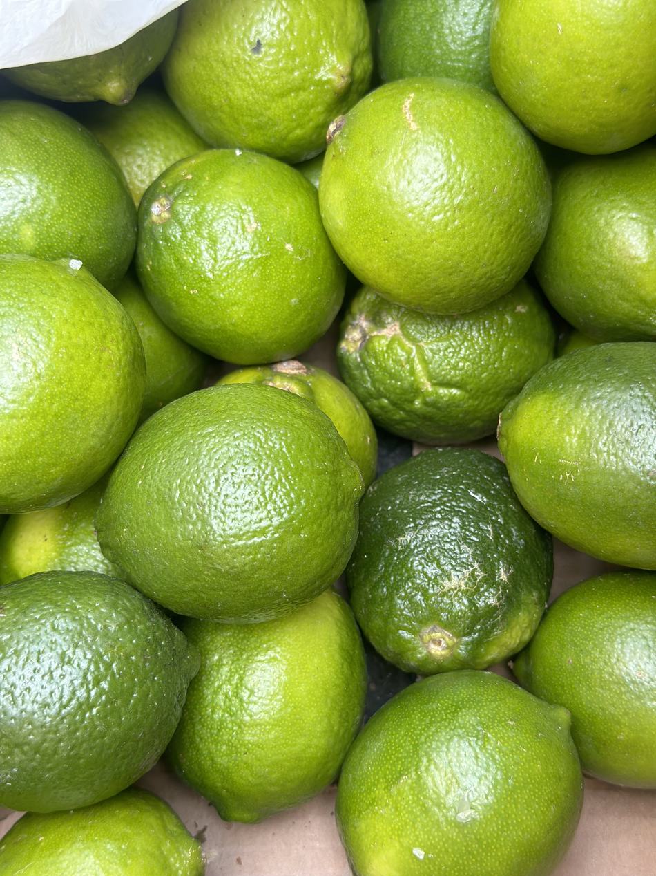 A crate of limes waiting to be cut