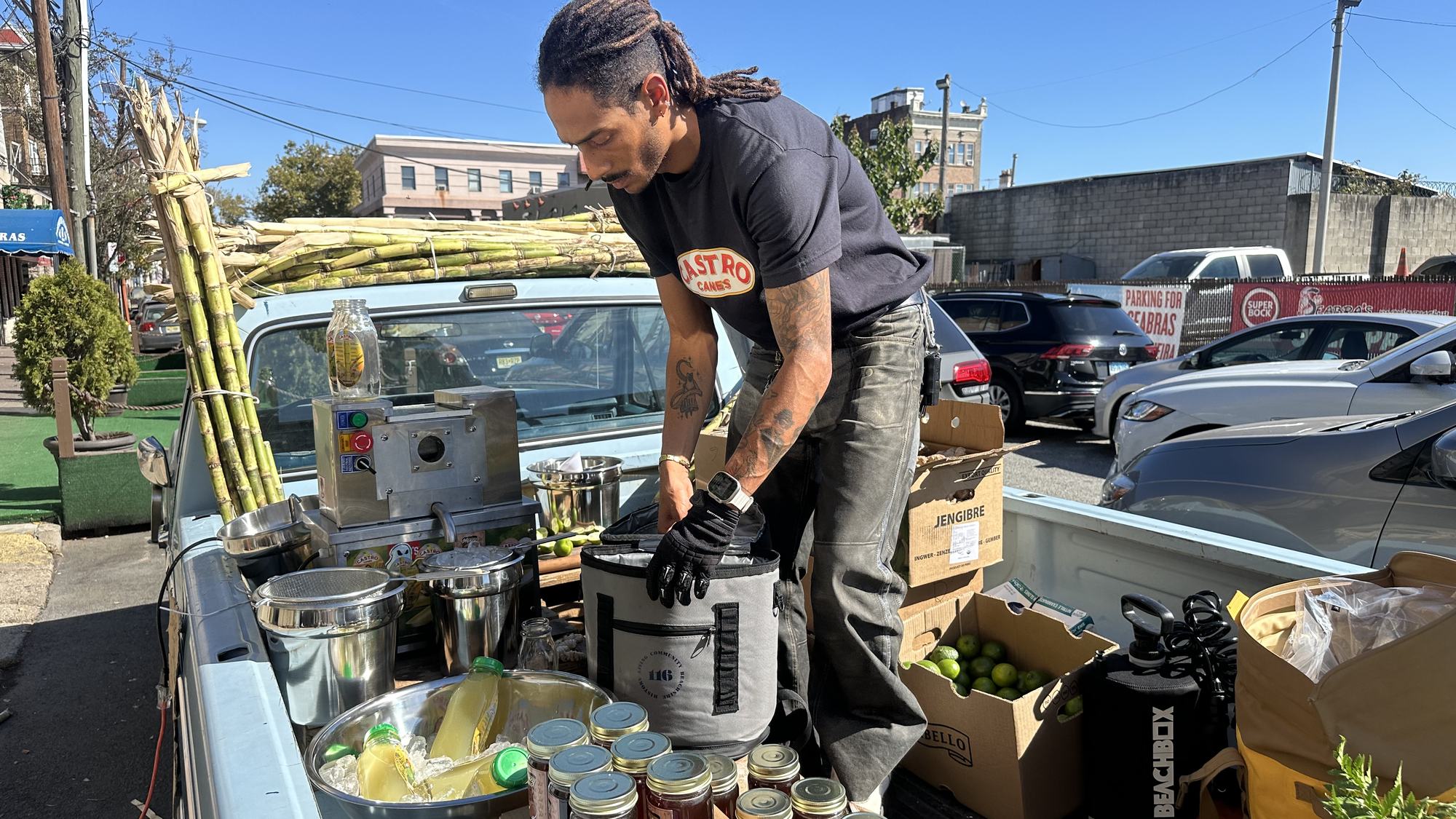 Pressing sugarcane at the tailgate of the vintage pickup outside ODR Studio