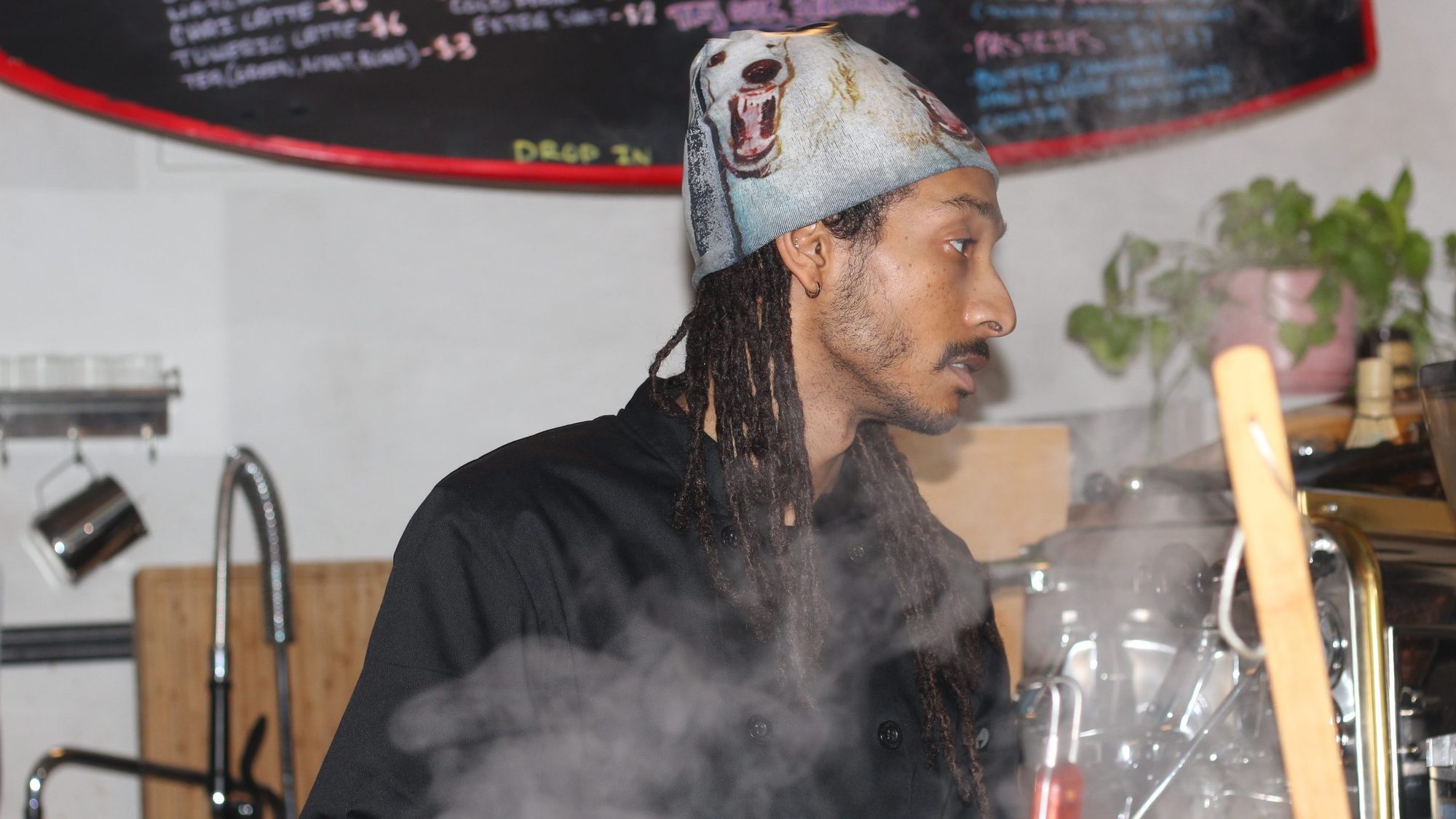 The chef working behind the counter as steam rises through the room
