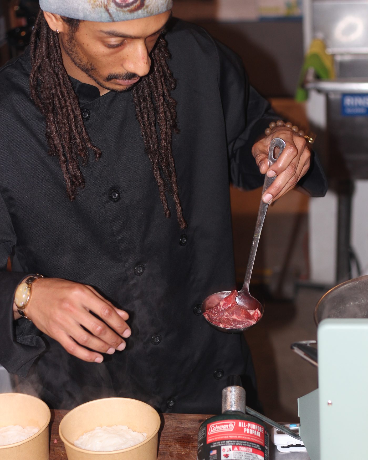 Raw beef lowered by ladle into the waiting bowls