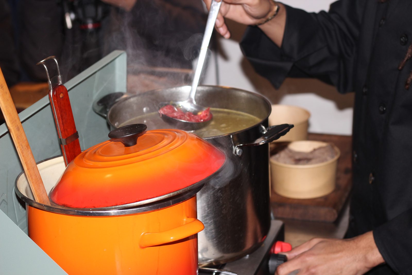 The stockpot and the orange pot side by side, steam rising between them