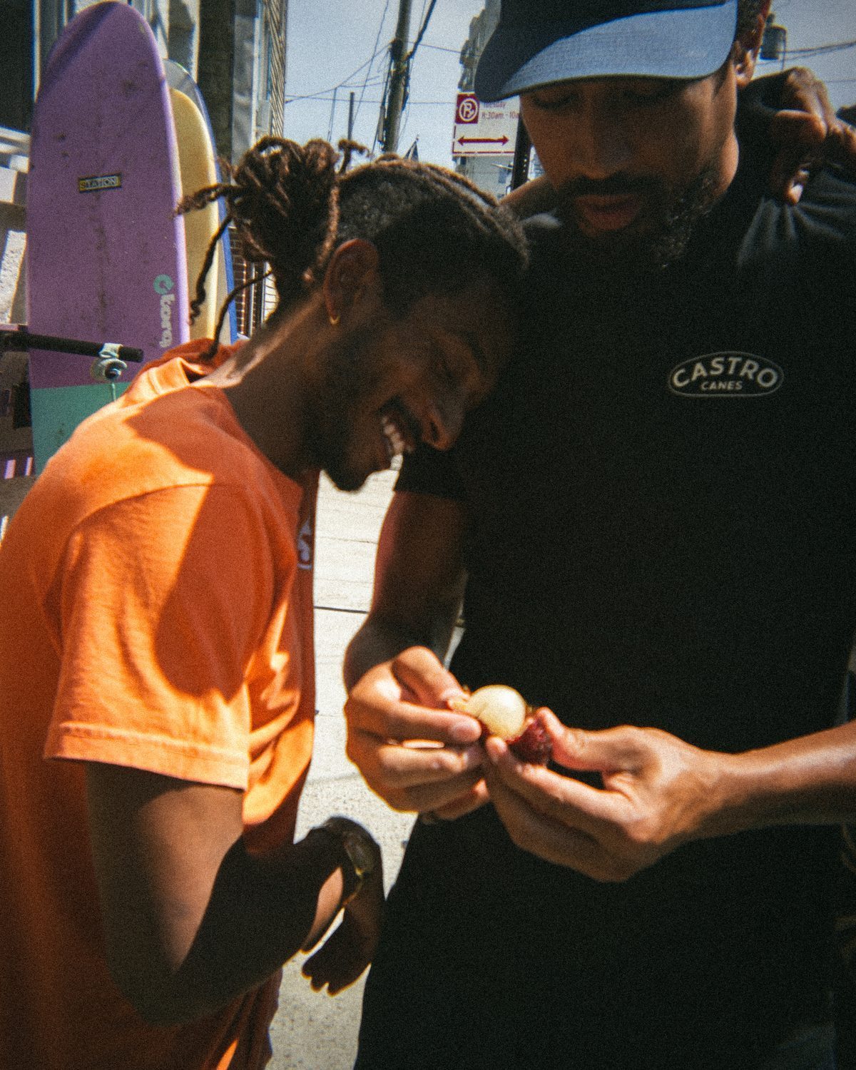 Two friends laughing over something held between them