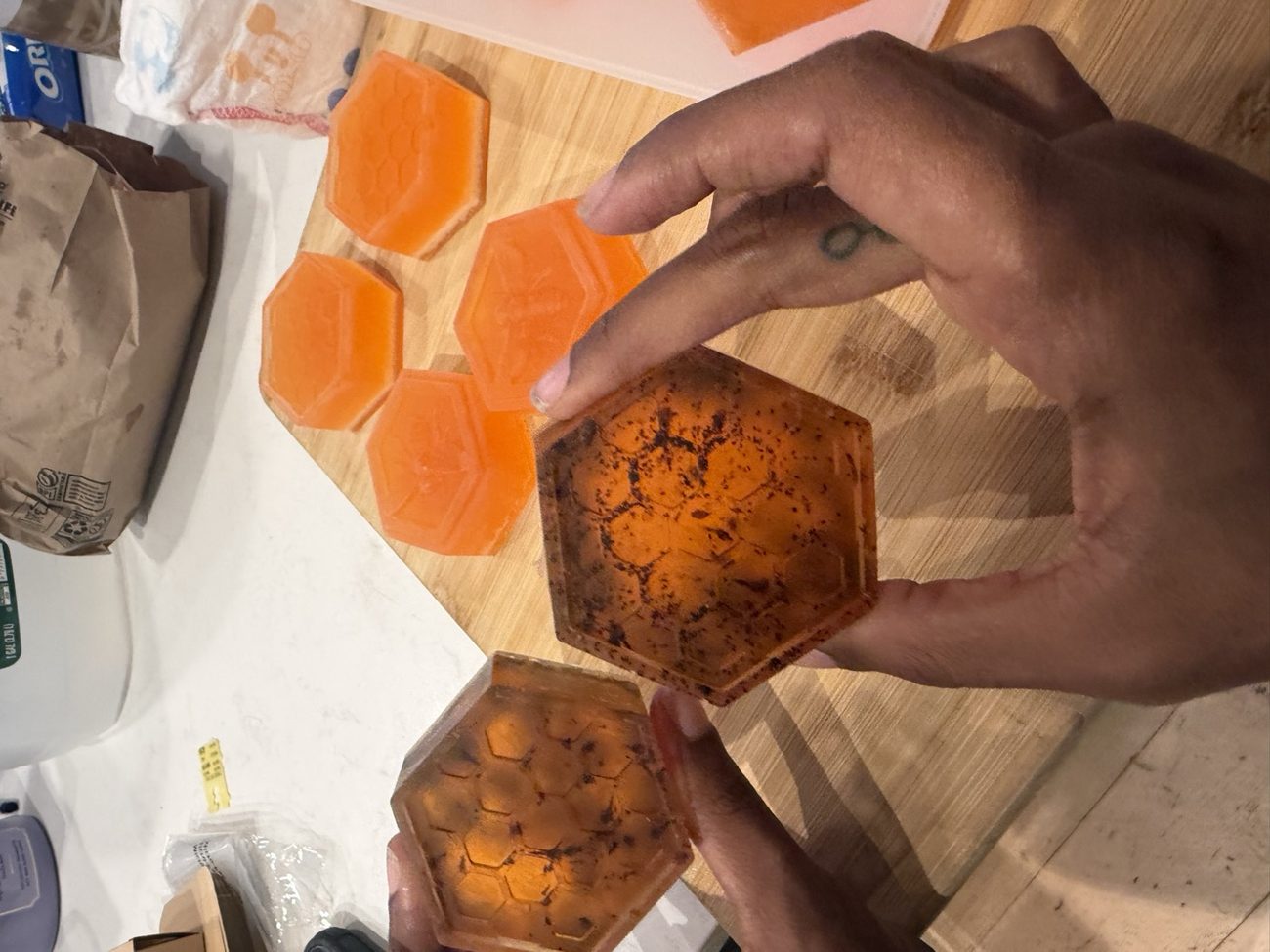 Honeycomb-textured raw-honey soap bars held in hand